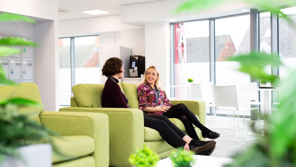 Wellbeing picture of people sat on sofa in office