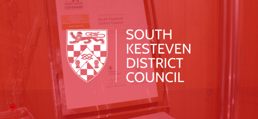 Image of a certificate in a display case. A red screen is overlaid. South Kesteven District Council logo in the centre. 